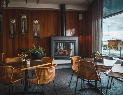 霍巴特海岸线酒店的一间带2张桌子和壁炉的餐厅