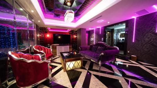 永和爱摩儿时尚旅舘的紫色客房配有两把椅子和一张桌子