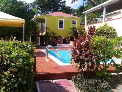 英吉利港安提瓜海洋酒店的一座黄色的房子,在院子里设有游泳池