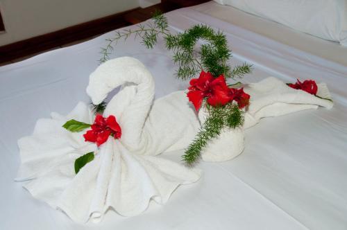 尼格瑞尔棕榈度假村的床上的毛巾天鹅和红色鲜花