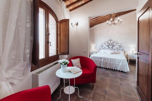 切塔尔多Antica Torre del Borgo的一间卧室配有红色椅子和一张床