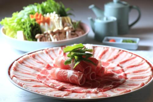 鹿儿岛鹿儿岛城山酒店的桌上一盘带肉和蔬菜的食物