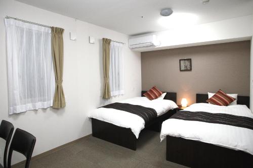 东松岛东松岛矢本最佳价值酒店 的客房设有两张床和窗户。