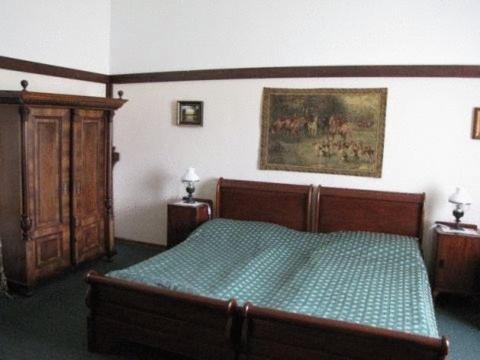 尼特拉扎莫克格洛法酒店的卧室配有一张床,墙上挂有绘画作品