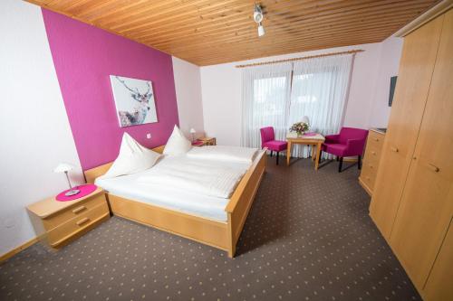 莱温Gästehaus-Weingut Loersch的卧室配有一张床和一张桌子及椅子