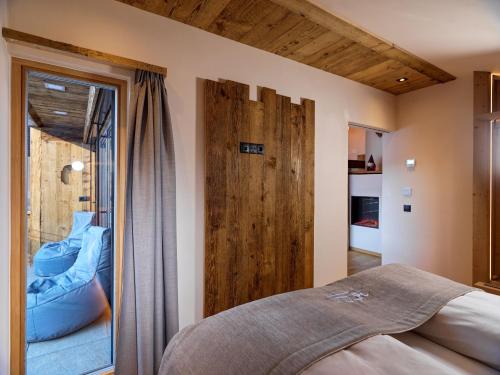 PrateriaHofchalet Heu - Örlerhof的一间卧室设有一张床和一个滑动玻璃门