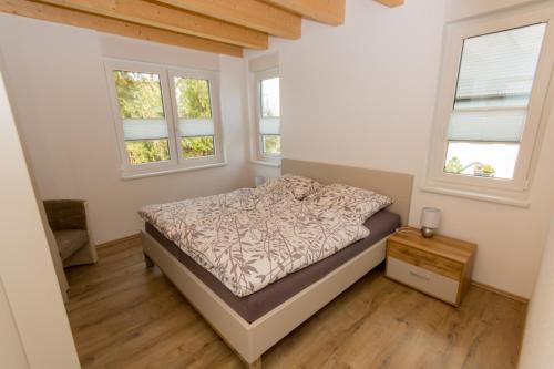 伦讷施塔特Ferienwohnung Stratmann的一间卧室设有一张床和两个窗户。