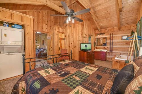 赛维尔维尔View! Cozy, Private, Fireplace, Hot Tub Log Cabin, Honeymoon!的一间卧室配有一张床和吊扇