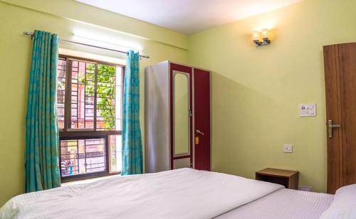 加尔各答Emerald By Olys Apartment的一间卧室设有一张床和一个窗口