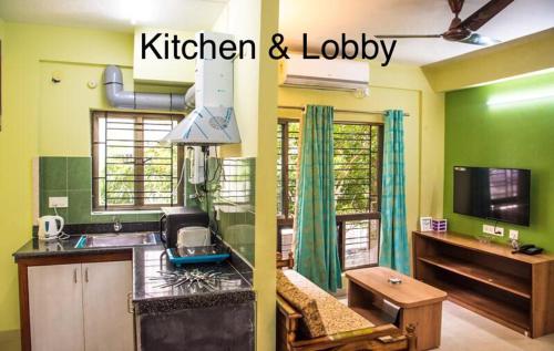加尔各答Emerald By Olys Apartment的一个带绿色墙壁的厨房、一间厨房和一个大堂