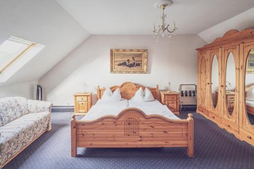 多尔马根Schloß Destille的一间卧室配有一张大型木床和一张沙发
