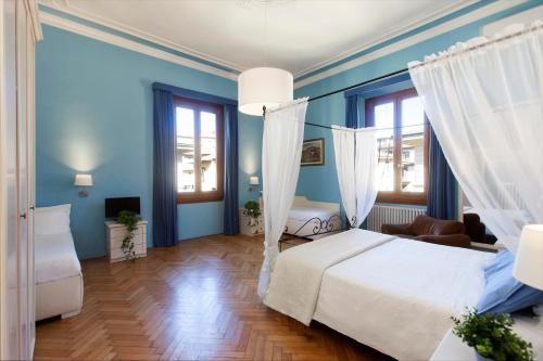 佛罗伦萨朱莉酒店的卧室配有白色的床和蓝色的墙壁