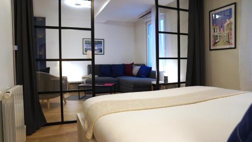 拉罗谢尔Appartements Les Rochelais的一间卧室设有一张床和一间客厅。