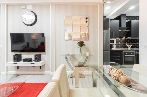 马德里Madrid Rio Apartment的一间带玻璃桌的客厅和一间厨房