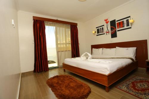 埃尔多雷特Merril Hotel的一间卧室设有一张大床和一个窗户。