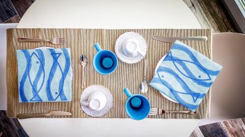 加埃塔La terrazza dei colori的切板上带盘子和餐具的桌子