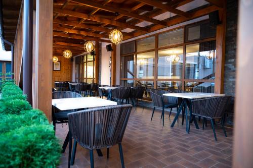 巴克乌Hotel Bohemia的餐厅设有桌椅和窗户。