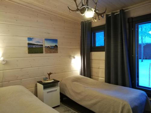 乌茨约基Lomatärppi的一间卧室设有两张床和窗户。