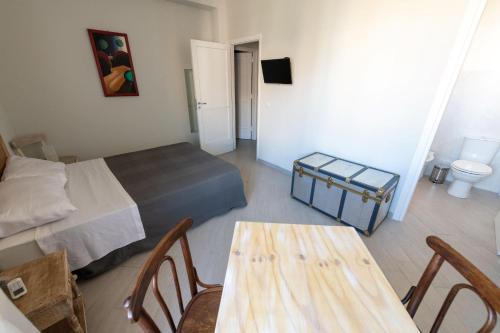卡塔尼亚" DOMUS CORALLA" BnB Racconti Di Viaggio的一间卧室配有一张床和一张桌子及椅子