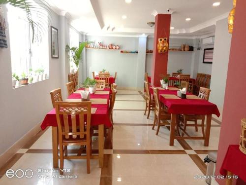 勃固The Pegu Lodge的一间餐厅,房间内设有红色的桌椅