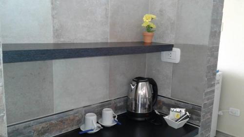 科连特斯NEFERET Habitaciones Temporarias的厨房柜台配有茶壶和茶杯