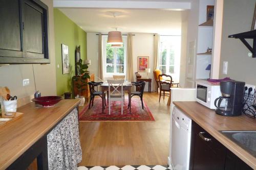 索恩河畔沙隆Le Clos 25的厨房以及带桌椅的起居室。