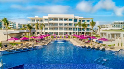 坎昆Planet Hollywood Cancun, An Autograph Collection All-Inclusive Resort的粉红色遮阳伞的度假村游泳池形象