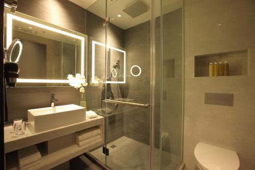 香港紫珀酒店的带淋浴、盥洗盆和卫生间的浴室