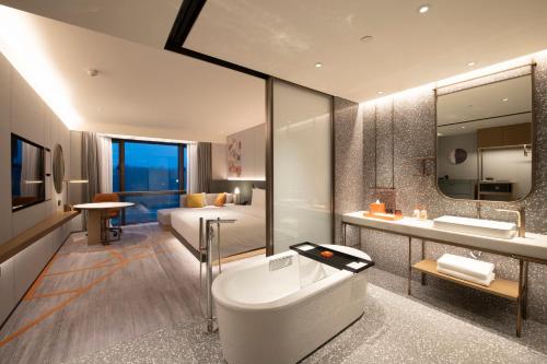 延庆县北京金隅八达岭皇冠假日酒店的带浴缸、水槽和床的浴室
