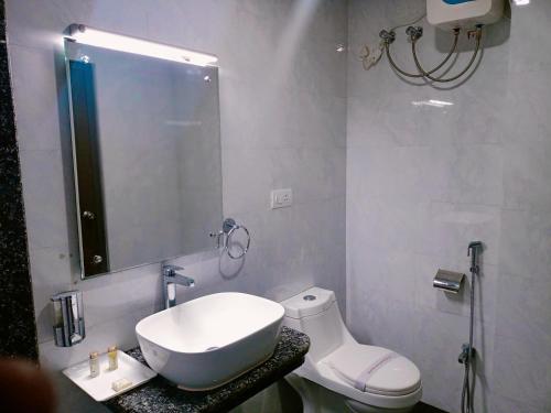 普里Hotel Vip Square的一间带水槽、卫生间和镜子的浴室