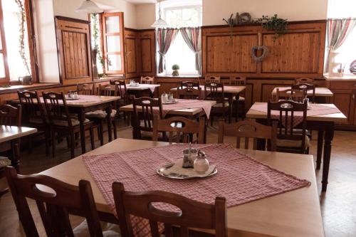 基姆高地区阿绍坎盆旺德阿绍宾馆的用餐室设有桌椅和窗户。