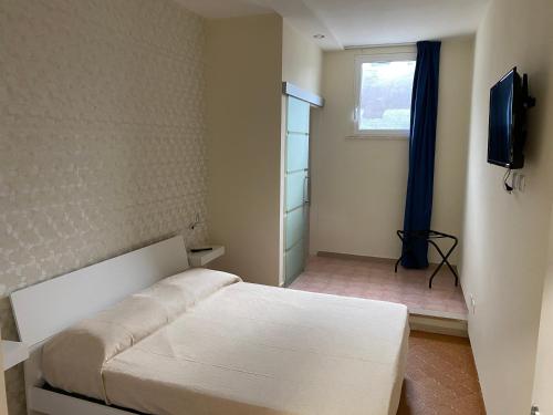 圣温琴佐Acquaviva Experience B&B的卧室配有白色的床和电视。