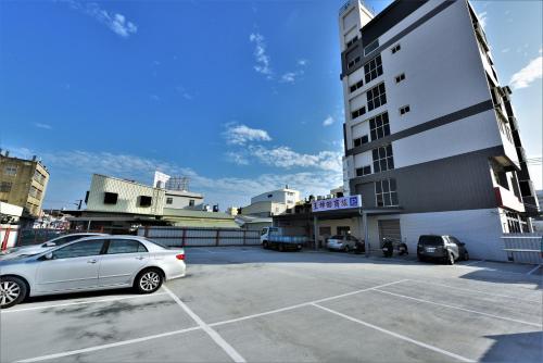 Shalu玉坤田商旅 的停在大楼旁边的停车场的汽车
