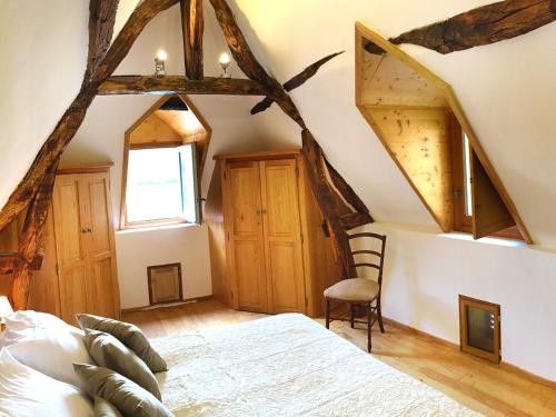 贝纳克和卡泽纳克Maison O'Galop的一间卧室设有床、窗户和木制天花板
