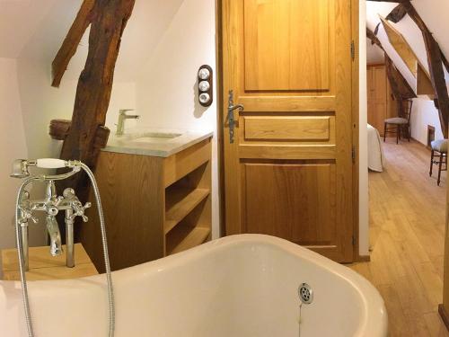 贝纳克和卡泽纳克Maison O'Galop的带浴缸的浴室和木门