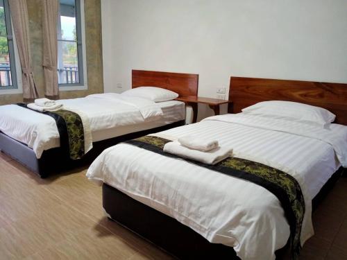 湄宏颂Jeerang Countryside Resort的配有白色床单的酒店客房内的两张床