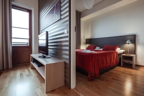 易拉斯加威拉普兰萨迦酒店的一间卧室配有一张床和一台电视