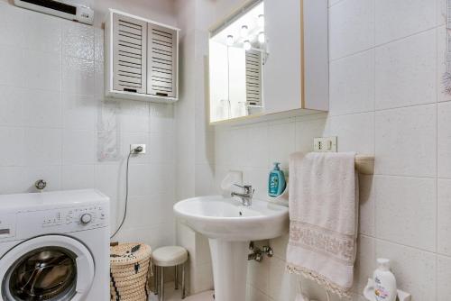 博曾安古Mansarda tra le Dolomiti di Brenta的白色的浴室设有水槽和洗衣机。