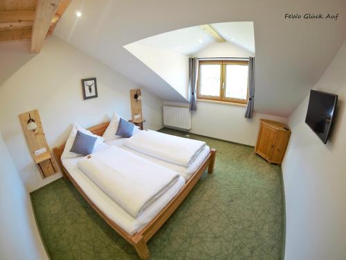 柯尼希斯湖畔舍瑙Gästehaus Siegllehen的阁楼上的卧室配有一张大床