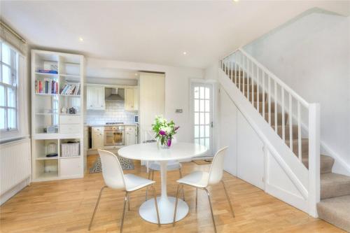 布莱顿霍夫Charming Cottage & Garden - central Brighton!的白色的用餐室配有白色的桌椅