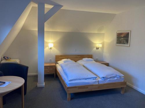 比勒费尔德温特姆勒酒店的一间卧室配有一张带蓝色枕头的床。