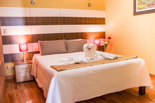 阿雷基帕Serk'ana Suite Hostal的一间卧室配有一张带两个天鹅的床