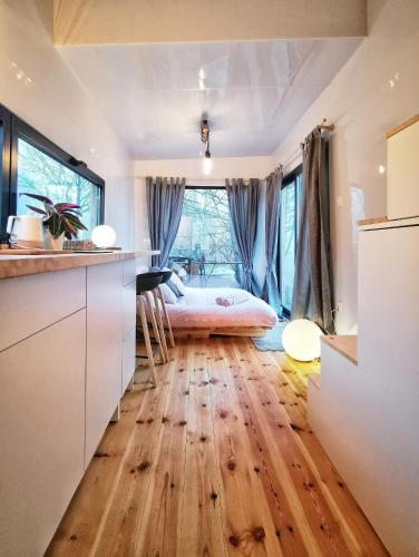 ReguliceLushHills - Tiny House - Modern House On Wheels的一间卧室配有一张床,铺有木地板