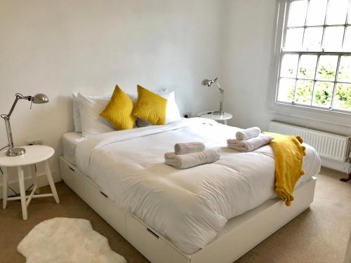 布莱顿霍夫Charming Cottage & Garden - central Brighton!的卧室配有白色床和毛巾