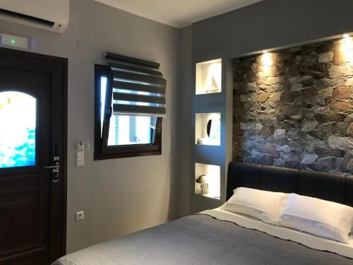 沃尔沃罗Anna - Tsiara paradise studios的一间卧室设有一张床和石墙