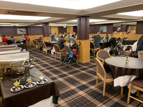 凯尔索凯尔索克劳斯吉斯酒店的一间设有桌子的餐厅,有坐在桌子上的人