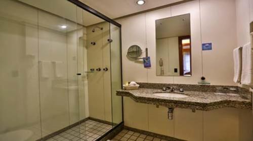 巴西利亚Condomínio Master Metropolitan -Centro de Brasília的一间带玻璃淋浴和水槽的浴室