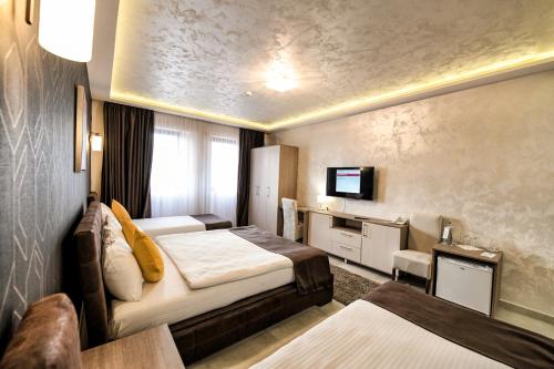 鲁马Garnet Hotel & Event Centar的酒店客房设有两张床和电视。
