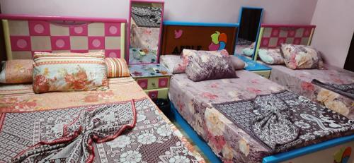 曼苏拉Al Mansoura Apartment的带3张床、毯子和枕头的客房