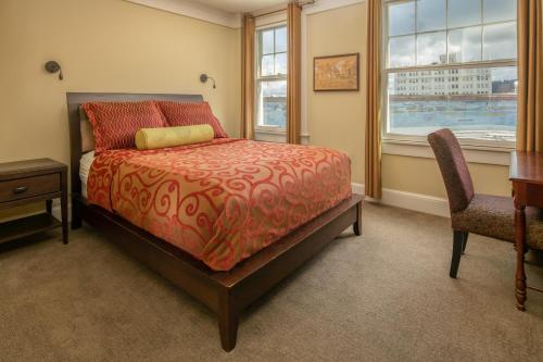 阿斯托里亚Hotel Elliott的一间卧室配有一张床、一张桌子和两把椅子
